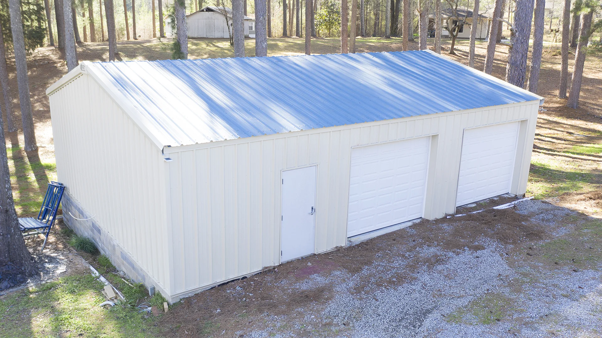 Light Stone Centra Series building kit with blue metal roof in a wooded setting